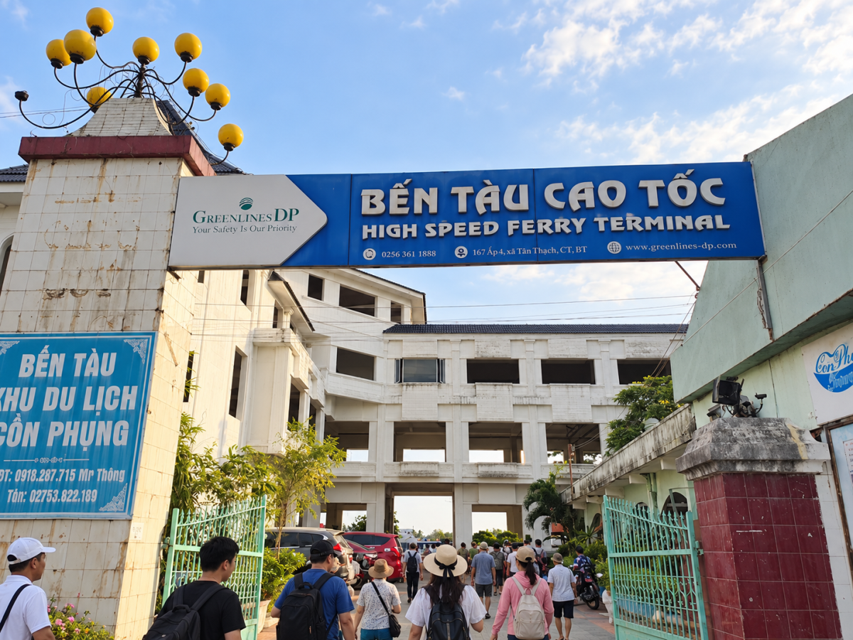 Lối vào bến tàu khu du lịch Cồn Phụng với biển hiệu bến tàu cao tốc, cổng chính và du khách đang di chuyển vào khu vực bến.