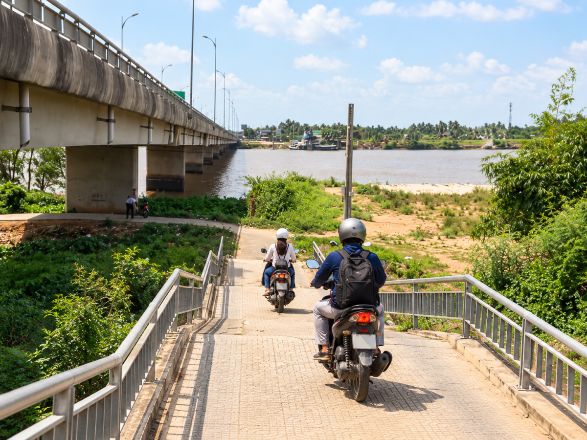 Người đi xe máy xuống lối đường dốc dưới cầu Rạch Miễu để tiếp cận Cồn Phụng.